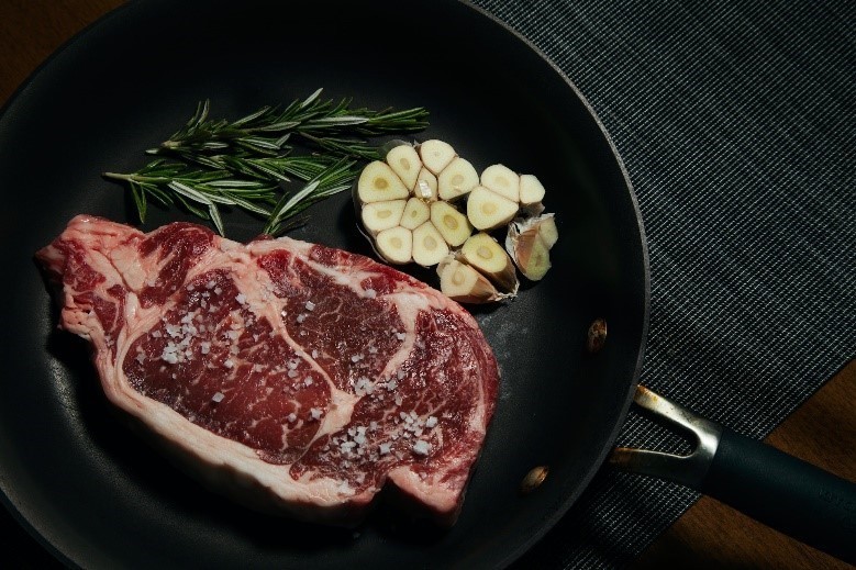 flat iron steak in een pan met rozemarijn en knoflook